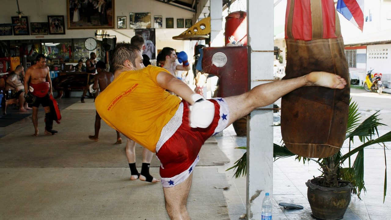 Muay Thai fighter throwing a high roundhouse kick in Thailand