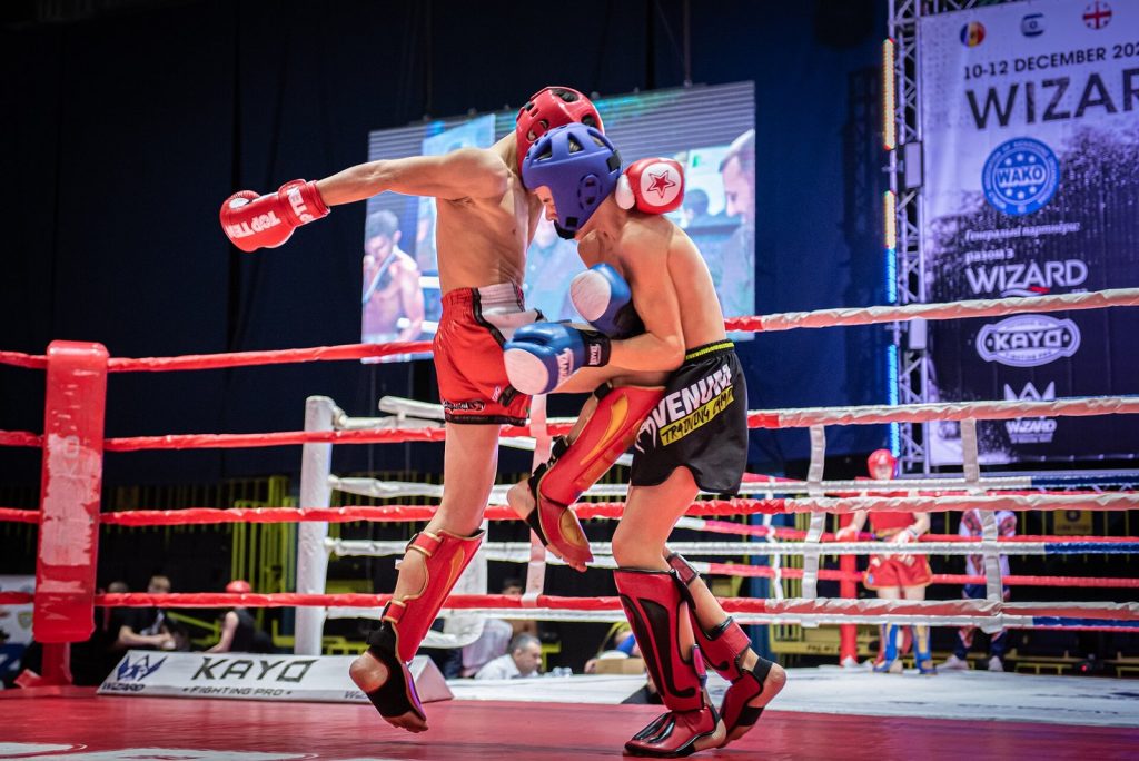 Two kickboxers exchanging strikes in a ring under K-1-style rules