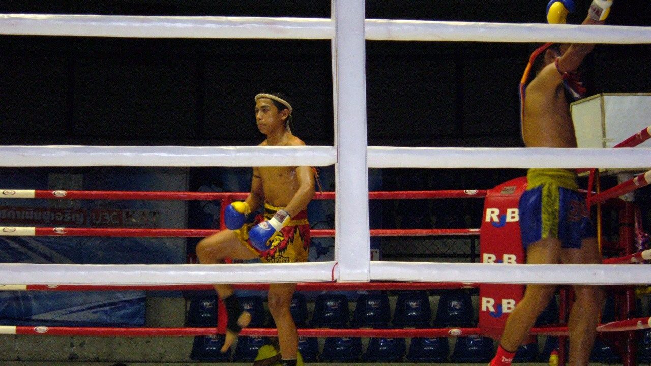 Two Muay Thai fighters in the ring at Rajadamnern Stadium in Bangkok